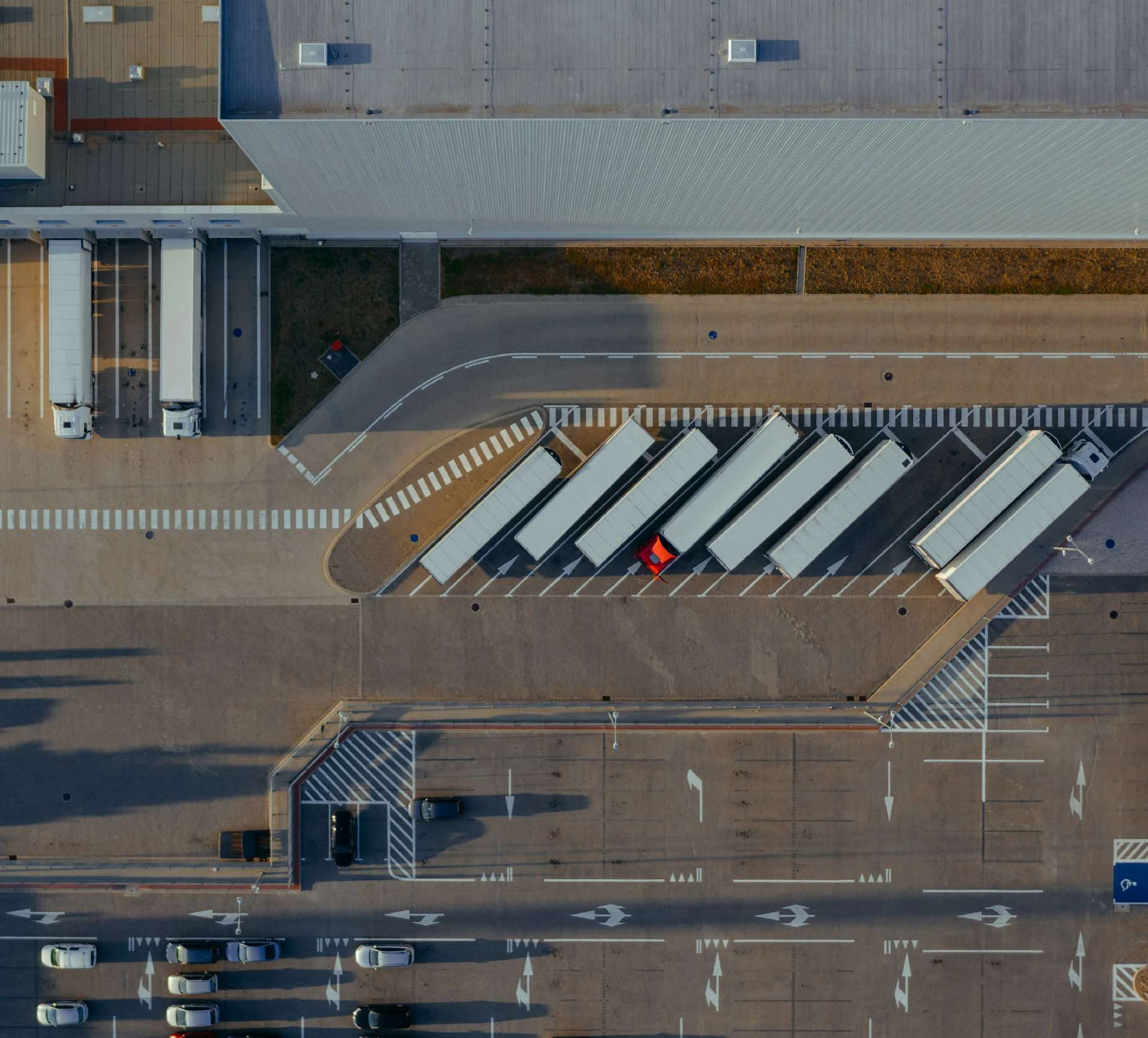 Aerial view of trucks and cars parked at a logistics yard